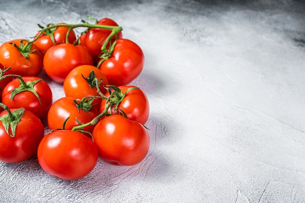 Fresh red tomatoes on kitchen table. White background. Top view. Copy space.