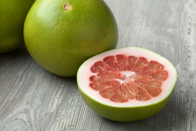 Photo fresh red whole and halved pomelo fruit close up