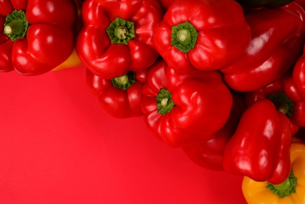 Fresh red yelow green bell pepper on a red background