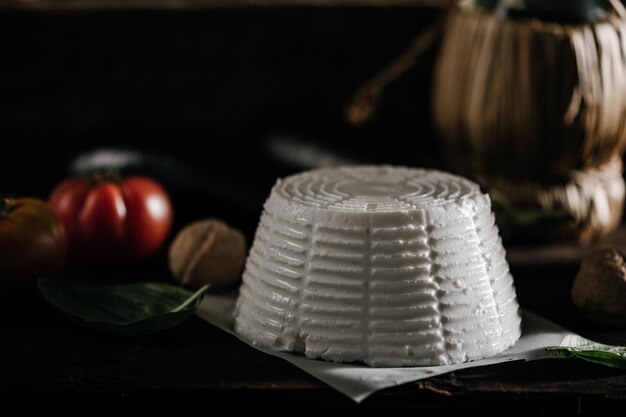 Fresh ricotta cheese on wooden background