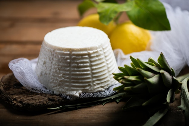 Fresh ricotta cheese on wooden backgroundxDxA