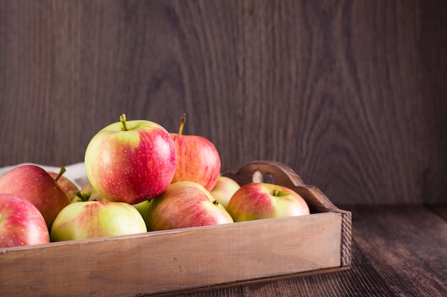 Fresh ripe apples in a box on a wooden table Local seasonal fruits