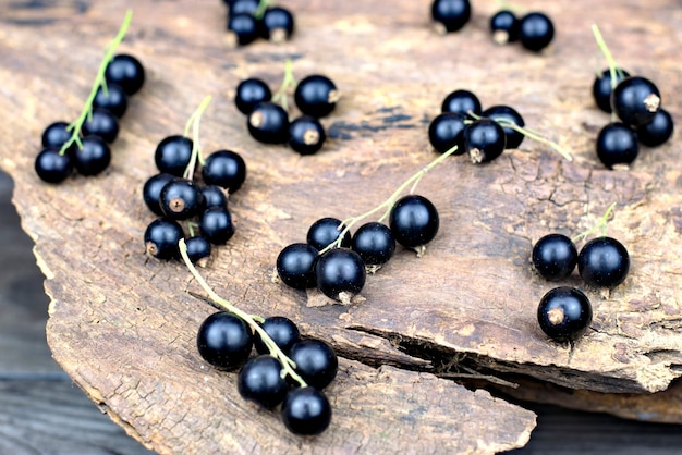 Fresh ripe black currants on an old wooden background.