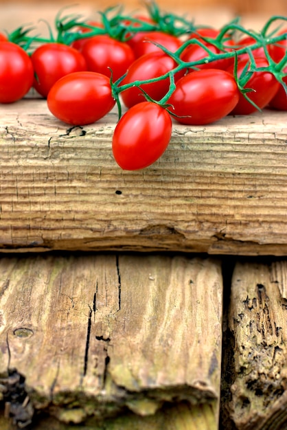  Fresh ripe cherry tomatoes on old wooden background.