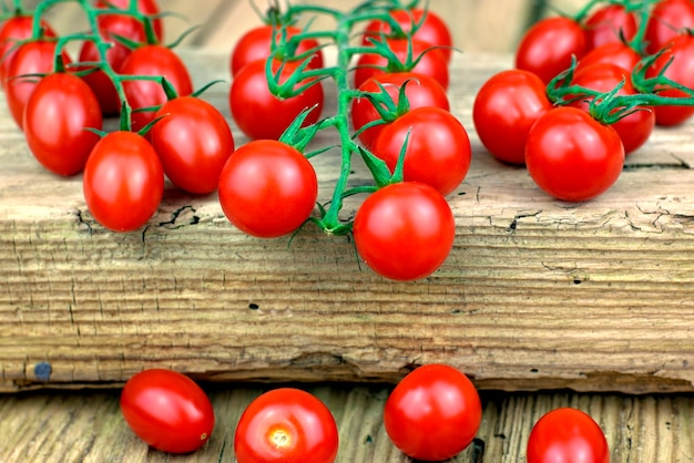  Fresh ripe cherry tomatoes on old wooden background.