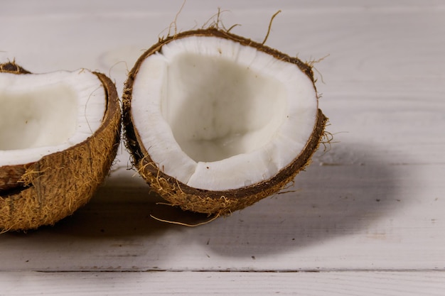 Fresh ripe coconut on white wooden table