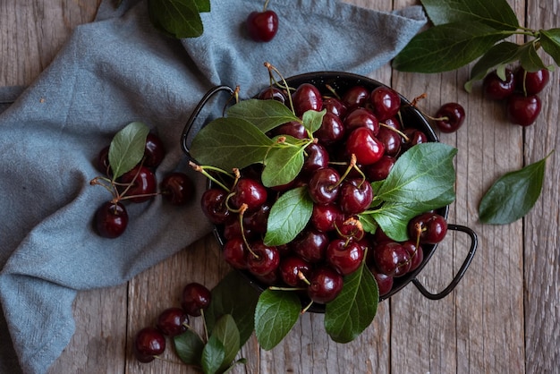 Fresh ripe dark cherry fruit with green leaves