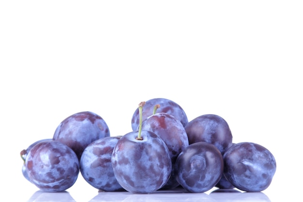 Fresh ripe delicious plums stacked in a pile on a white isolated background