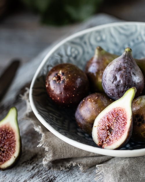 Photo fresh ripe figs in a bowl on a dark wooden table