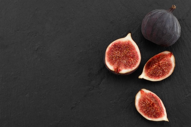 Fresh ripe figs on dark background, top view with copy space.