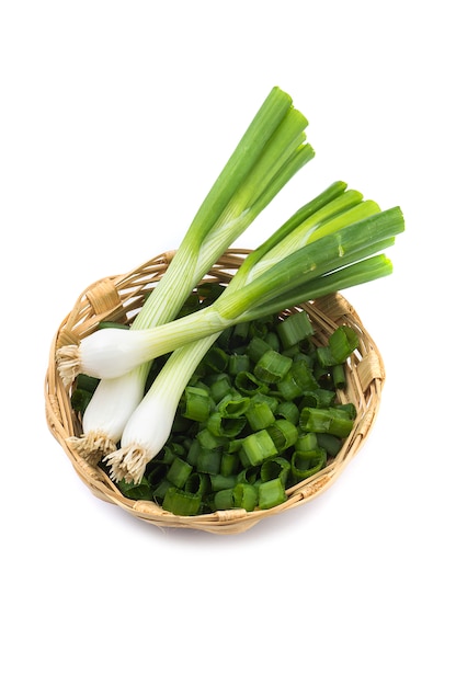 Fresh ripe green spring onions (shallots or scallions) with chopped onions in basket