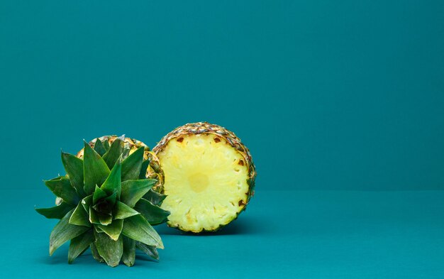 Fresh ripe halved pineapple on deep turquoise background