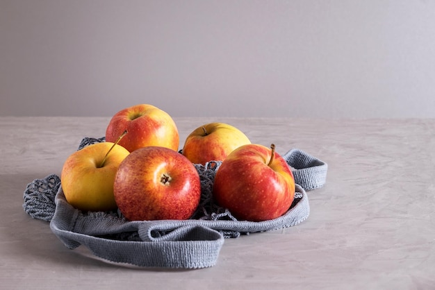 Fresh ripe juicy beautiful apples in eco-friendly reusable mesh bag made from recycled materials