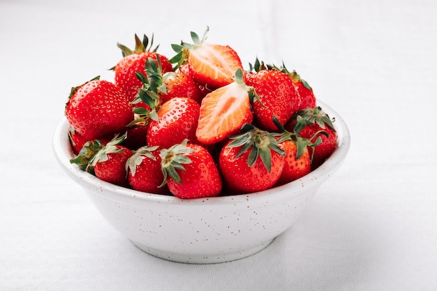 Fresh ripe juicy strawberries in a bowl on a white background