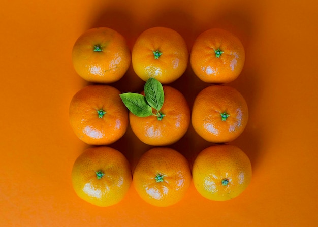 Fresh ripe mandarins on orange background