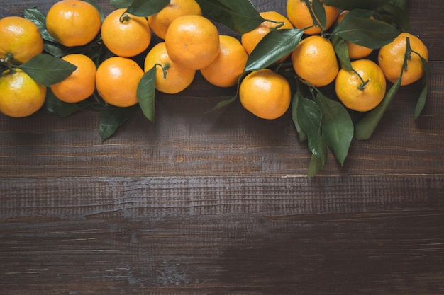 Fresh ripe mandarins with leaves on wooden board Christmas composition with copy space