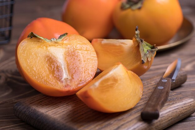 Fresh ripe, orange under persimmons cut into slices, close-up.