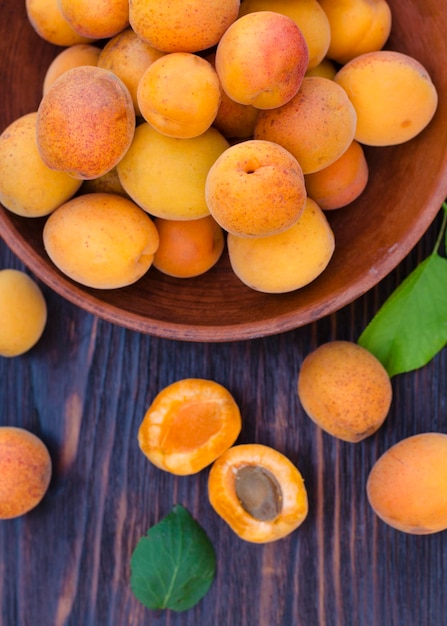 Fresh ripe organic apricots in a bowl with leaves table