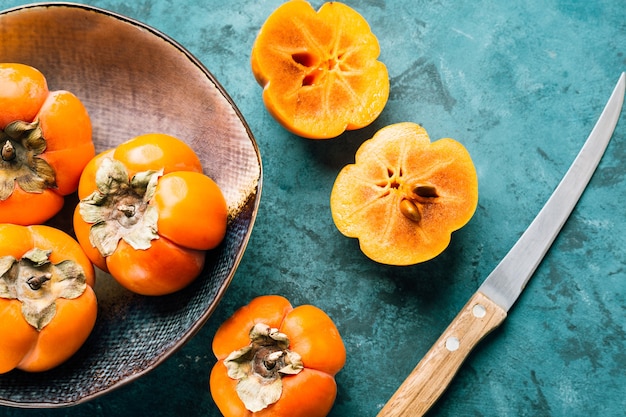 Fresh ripe persimmon on blue .