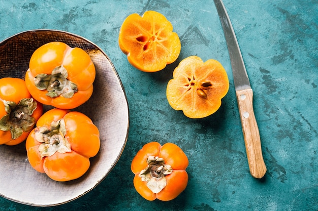 Fresh ripe persimmon on blue .