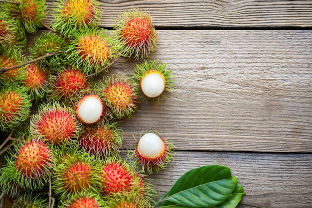 Fresh and ripe rambutan sweet tropical fruit peeled rambutan with leaf Rambutan fruit on wooden background harvest from the garden rambutan tree