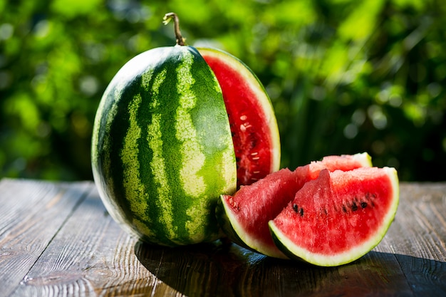 Fresh ripe striped sliced watermelon on wooden  background