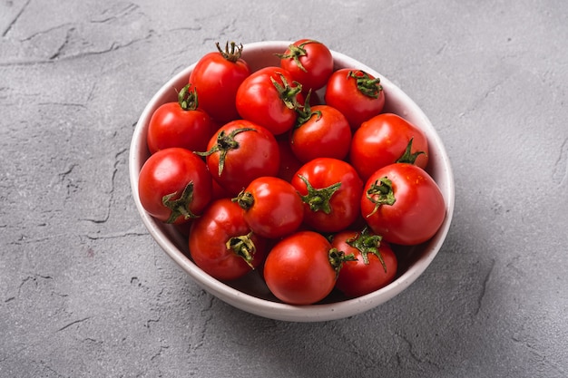 Fresh ripe tomatoes with water drops in bowl