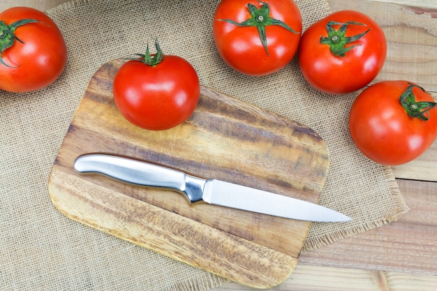 Fresh ripe tomatoes on wood background.