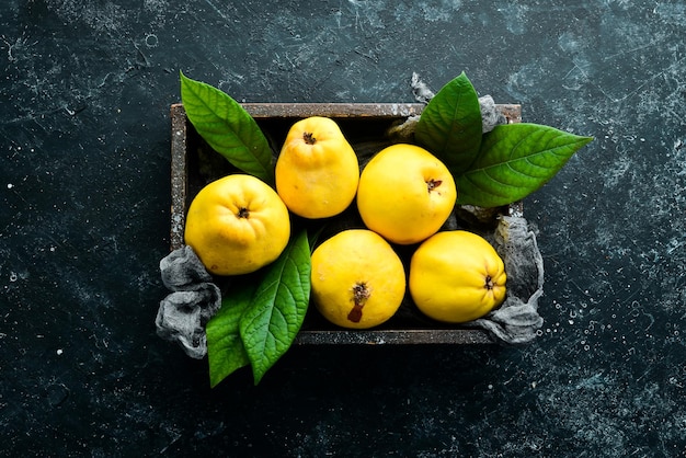 Fresh ripe yellow quince Fruits in a wooden box Top view Free space for text