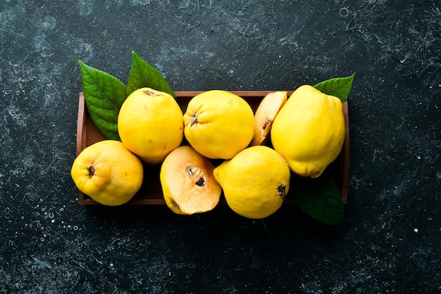 Fresh ripe yellow quince Fruits in a wooden box Top view Free space for text