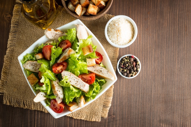 Fresh salad made of tomato, ruccola, chicken breast, eggs, arugula, crackers and spices. 