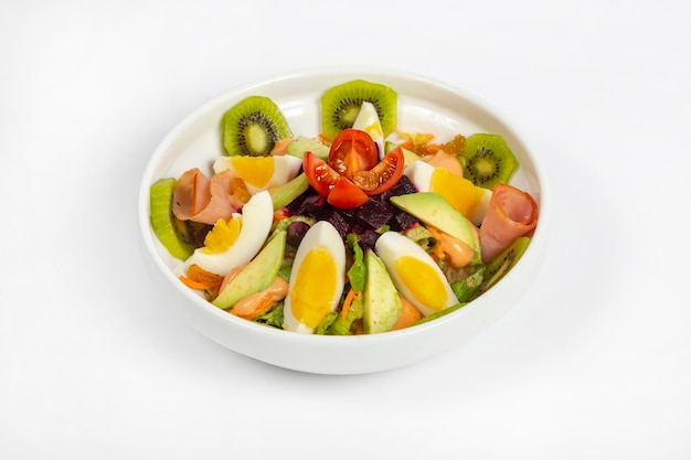 Fresh Salad made with fresh kiwi avocado eggs mixed vegetables on white bowl white background