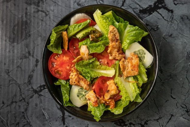 Fresh salad of romaine lettuce and tomatoes with roast chicken