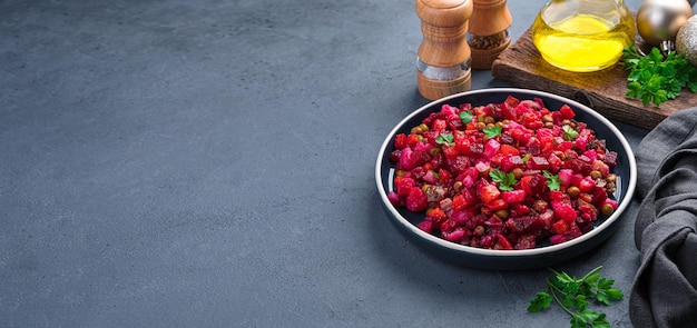 Fresh salad vinaigrette with vegetables peas and sauerkraut on a dark background