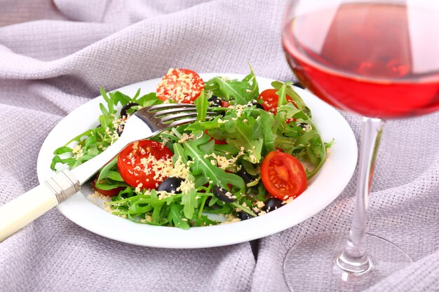 Fresh salad with arugula on fabric background