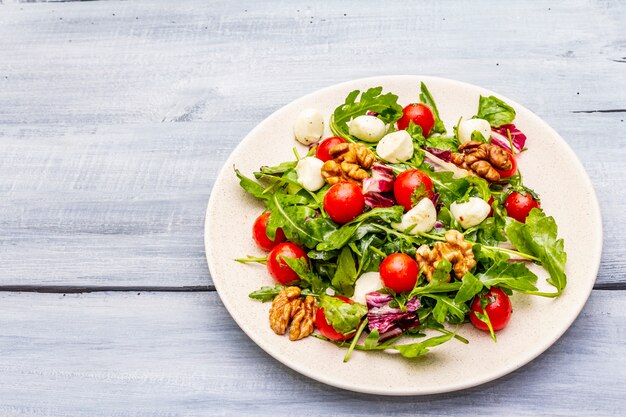 Fresh salad with arugula, radicchio, tomato cherry, baby mozzarella and walnuts