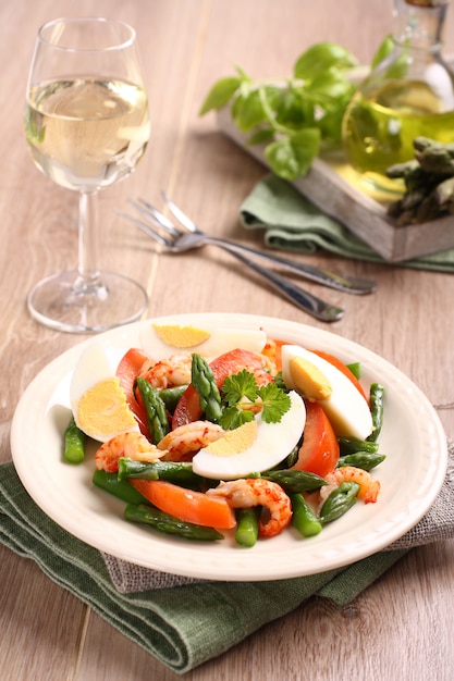 Fresh salad with asparagus, eggs, shrimp and tomatoes