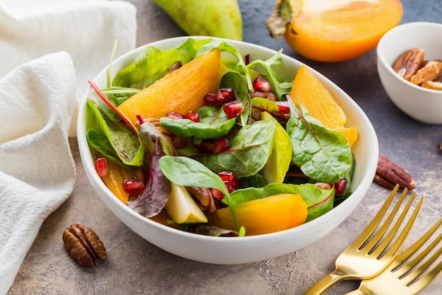 Fresh salad with fruits and greens on white background Healthy food