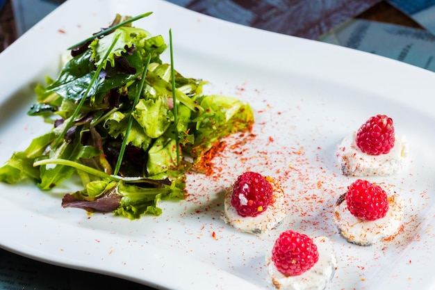 Fresh salad with goat cheese and raspberry