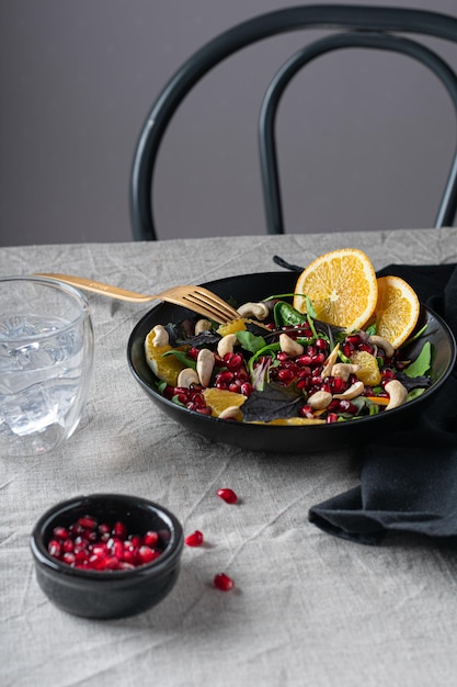 Fresh salad with orange and pomegranate seeds Vertical