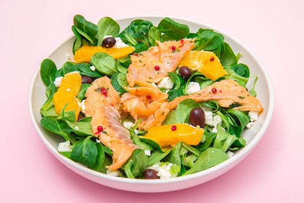 Fresh salad with sliced of marinated  salmon and orange fruit