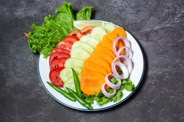 Fresh salad with tomato cucumber carrot onion green chilli leaves served in dish isolated on grey background top view of indian and bangladesh food