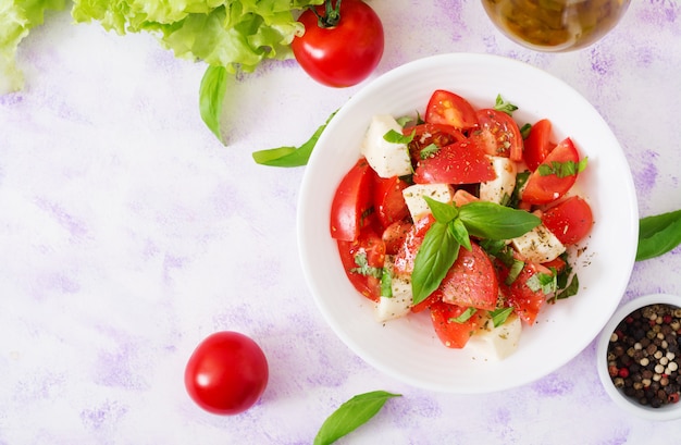 Fresh salad with tomato, mozzarella and basil. Top view