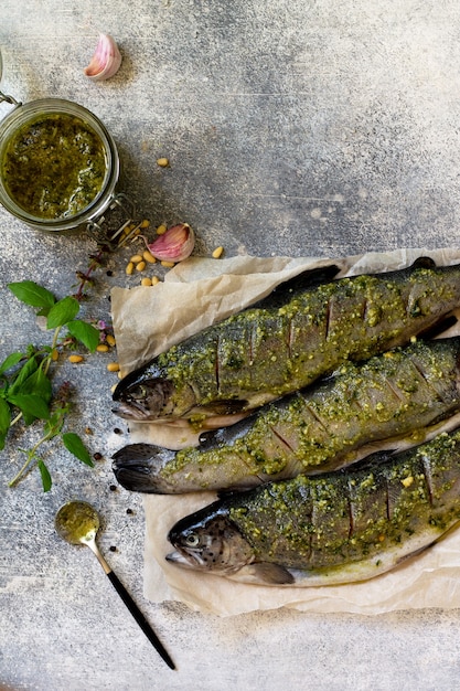 Fresh salmon preparation for baking Marinated fish with pesto sauce Top view Cope space