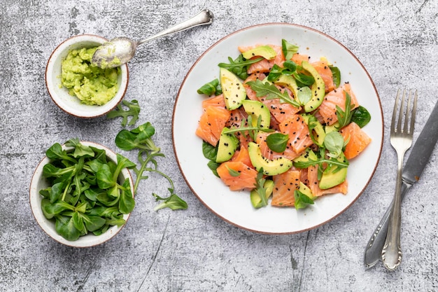 Fresh salmon salad with avocado,  for keto and low carb diet. Rusty background, top view, copy space.