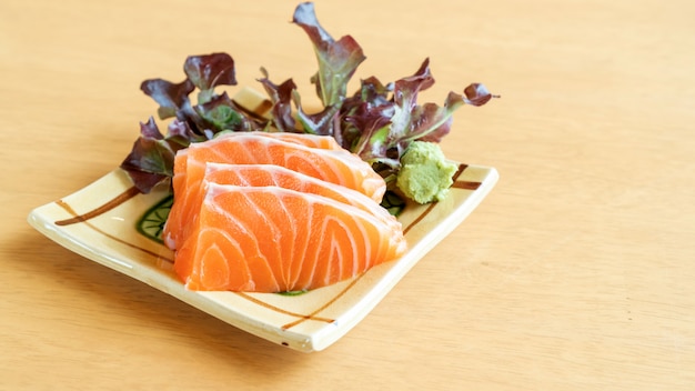 Fresh salmon sashimi on a wooden table.