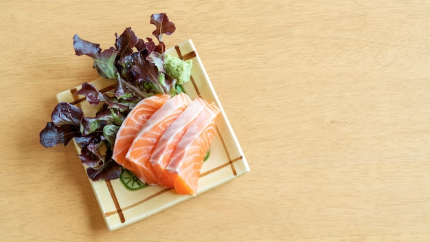 Fresh salmon sashimi on a wooden table.