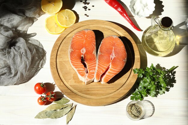 Fresh salmon steak with ingredients on  white wooden background