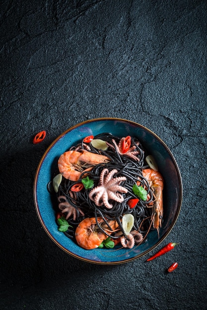 Fresh seafood black pasta made of octopus tiger prawns