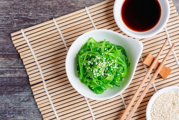 Fresh seaweed salad with soy sauce and white sesame, healthy vegetarian food. Top view with Copy space.